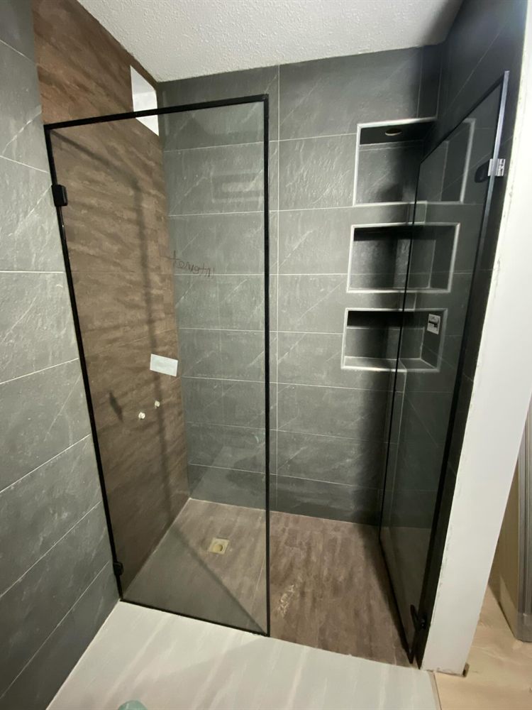 División de baño en vidrio templado con marco de aluminio negro